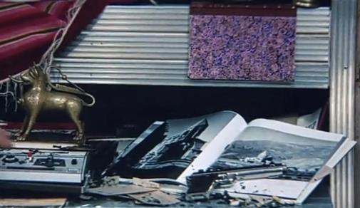 Guibariane'nin odasındaki kitapta görülen Kars Ani harabelerinin üzerinde küller, silah ve sigara izmaritleri.